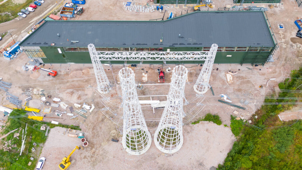 Four white landscape pylons side by side at a construction site area.