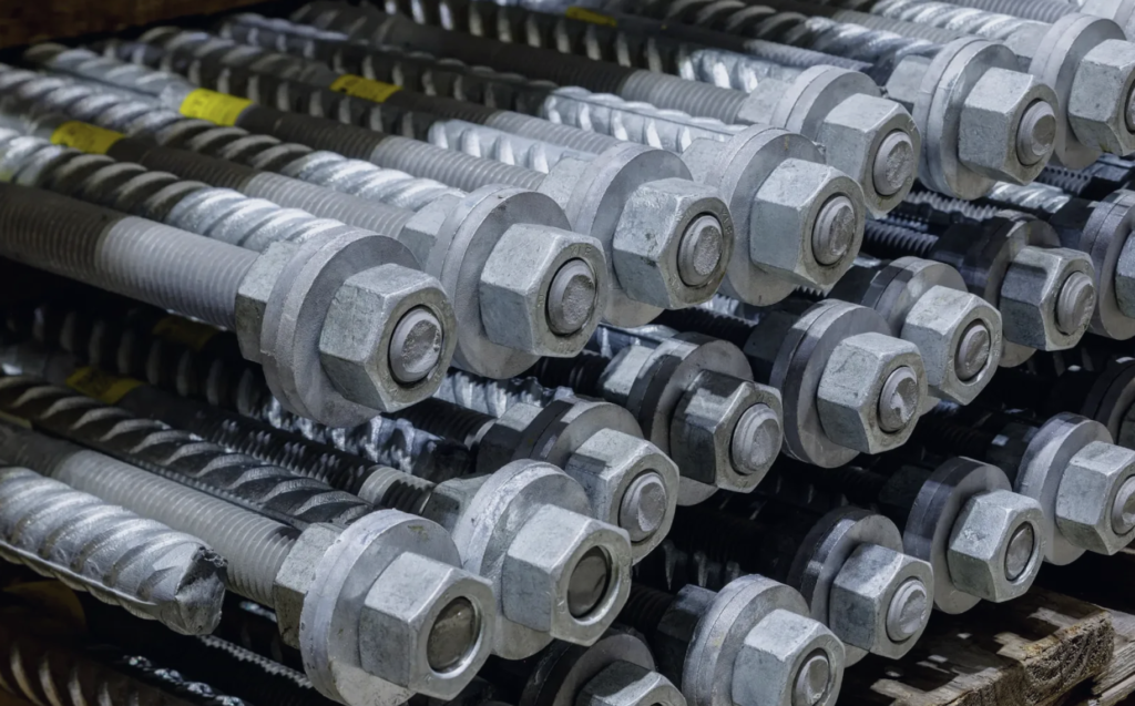 Hot-dip galvanized threaded bolts bundled on pallets.